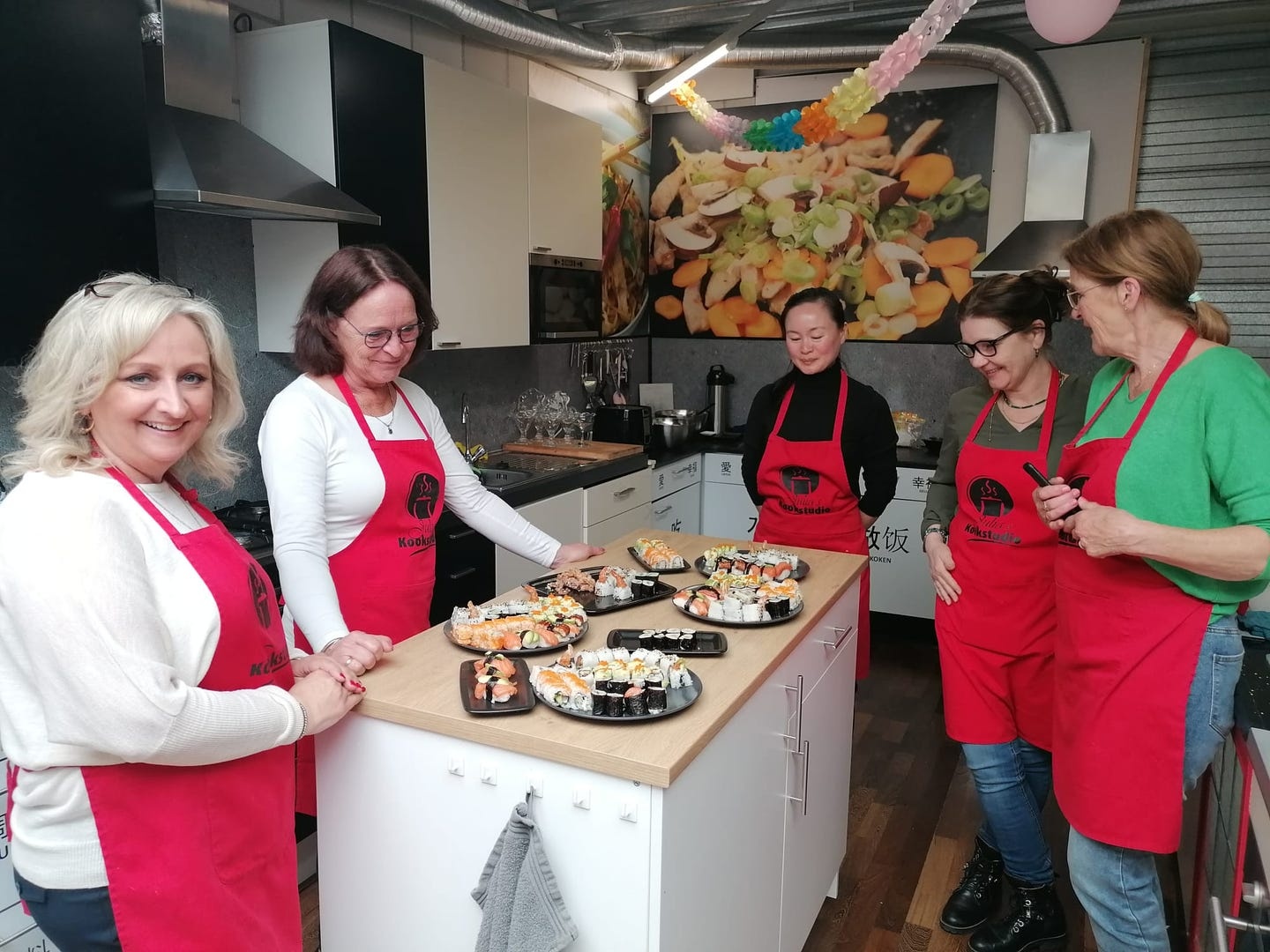 Vriendinnen rond de werktafel met borden vol sushi